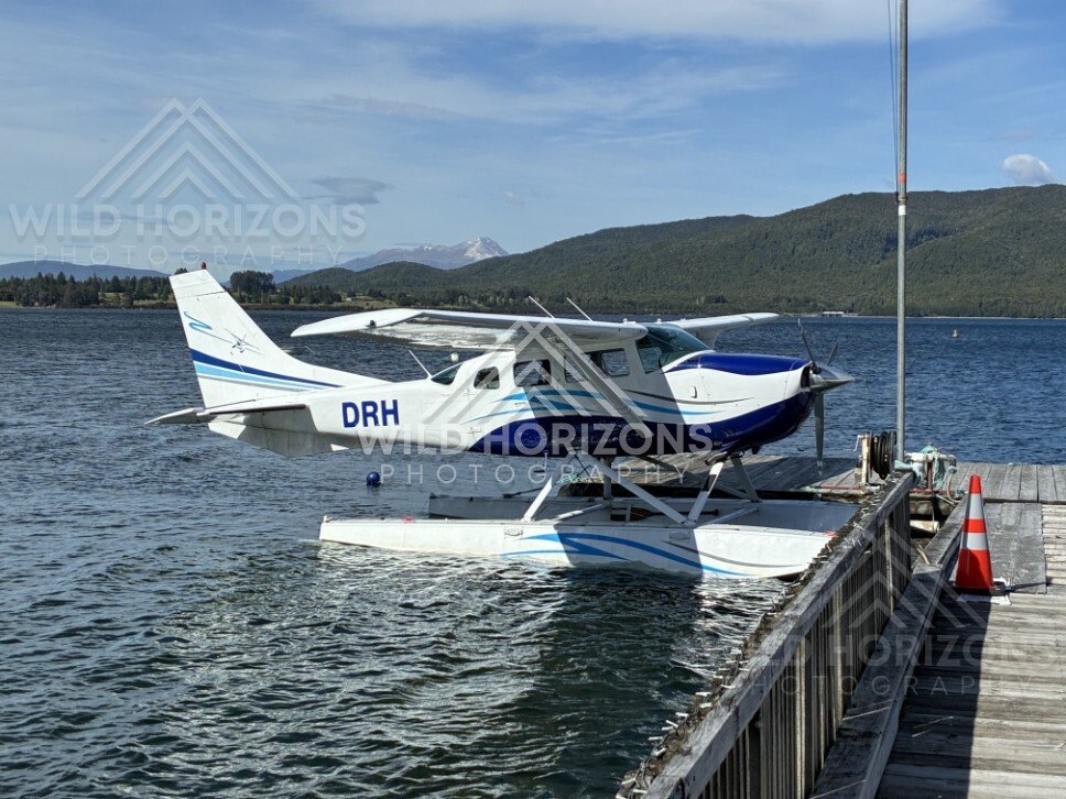Seaplane moored at jetty on mountain lake. Manapouri, New Zealand.