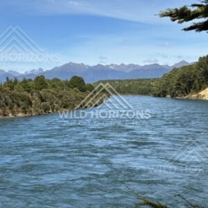 Wide river flowing through forested valley. Manapouri, New Zealand.