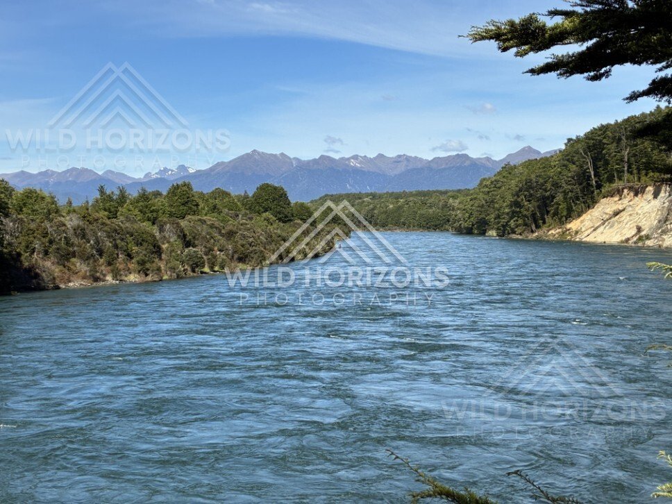 Wide river flowing through forested valley. Manapouri, New Zealand.