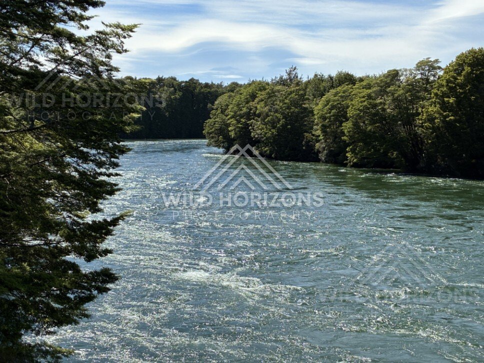 Fast-flowing river with textured surface and forested banks. Manapouri, New Zealand.