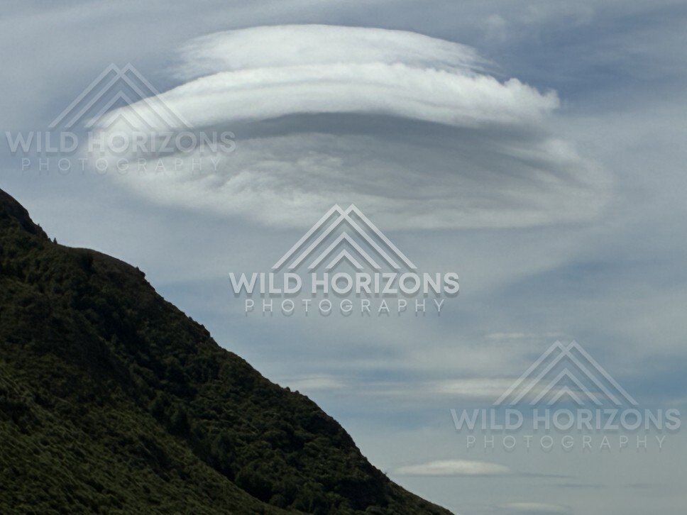 Lenticular cloud above mountain ridge. Kingston, New Zealand.