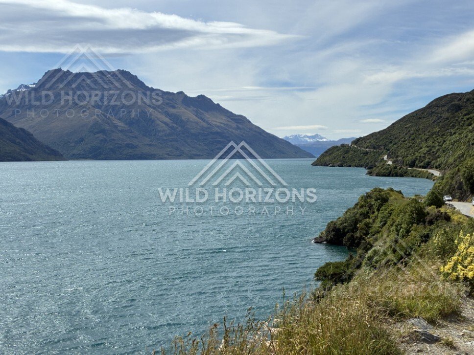 Curving shoreline with deep blue lake and mountains. Kingston, New Zealand.