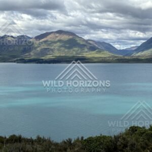 Still lake with mountain reflections under cloud. Glenorchy, New Zealand.