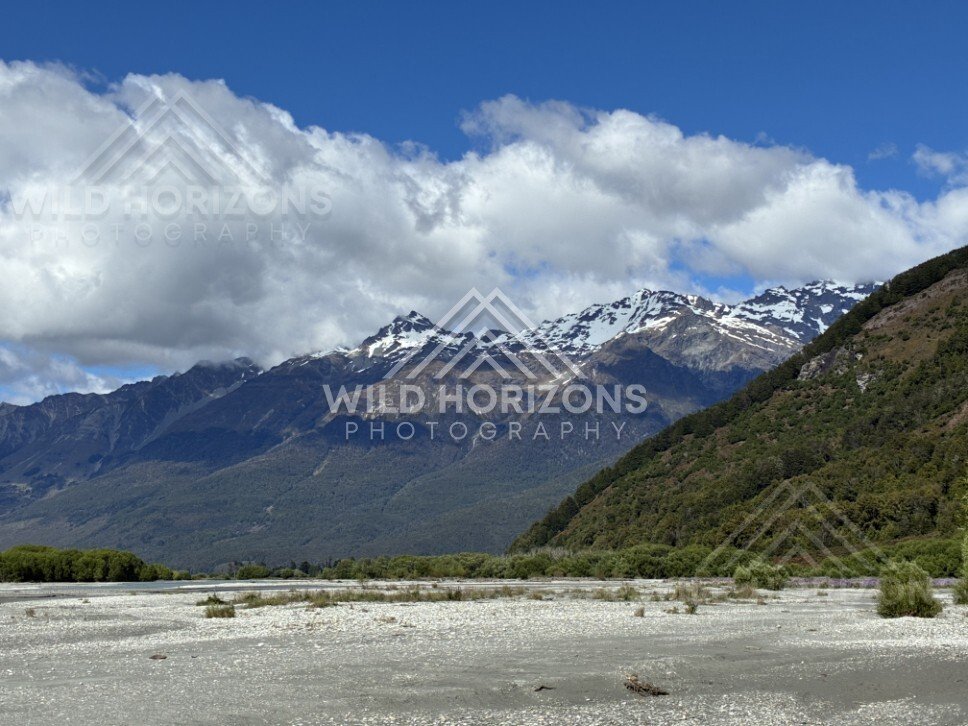 Gravel riverbed with snow-capped peaks beyond. Glenorchy, New Zealand.