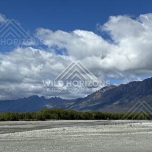 Wide riverbed with mountain range under scattered cloud. Glenorchy, New Zealand.
