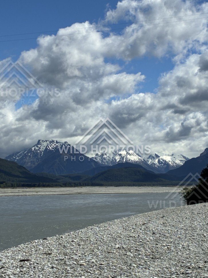 Lake with snow-capped peaks beneath broken cloud. Glenorchy, New Zealand.