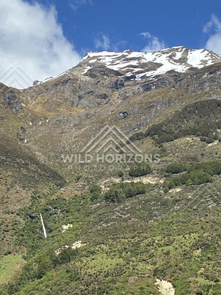 Mountain slope with winding waterfall. Glenorchy, New Zealand.