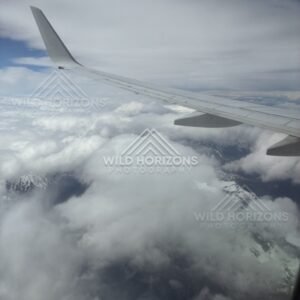 Aircraft wing above cloud and alpine landscape. Queenstown, New Zealand.