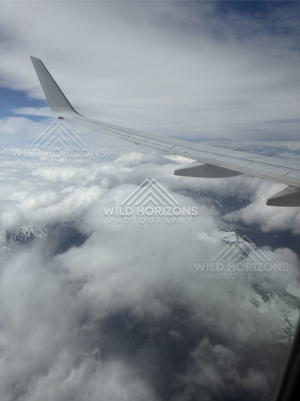 Aircraft wing above cloud and alpine landscape. Queenstown, New Zealand.