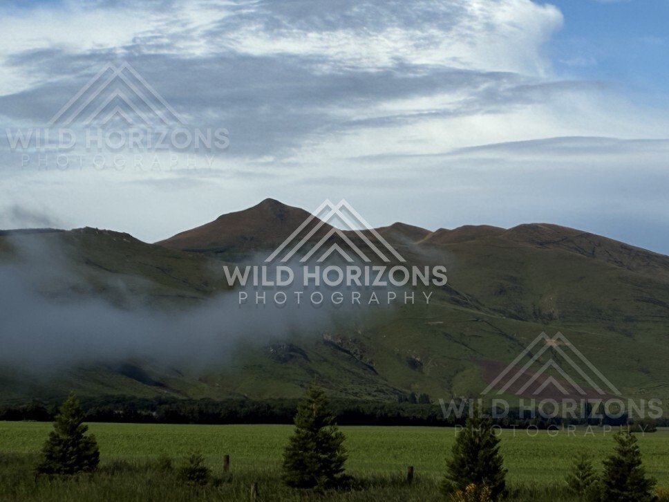 Low cloud drifting across green hills. Southland, New Zealand.