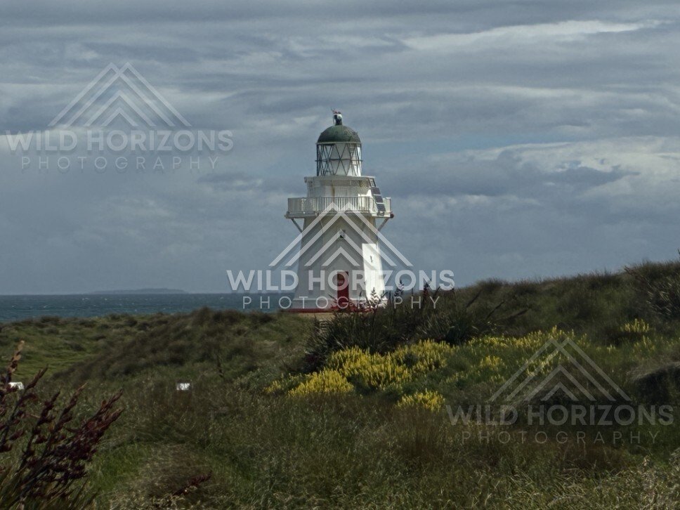 Waipapa Point lighthouse under dramatic cloud. Waipapa Point, New Zealand.