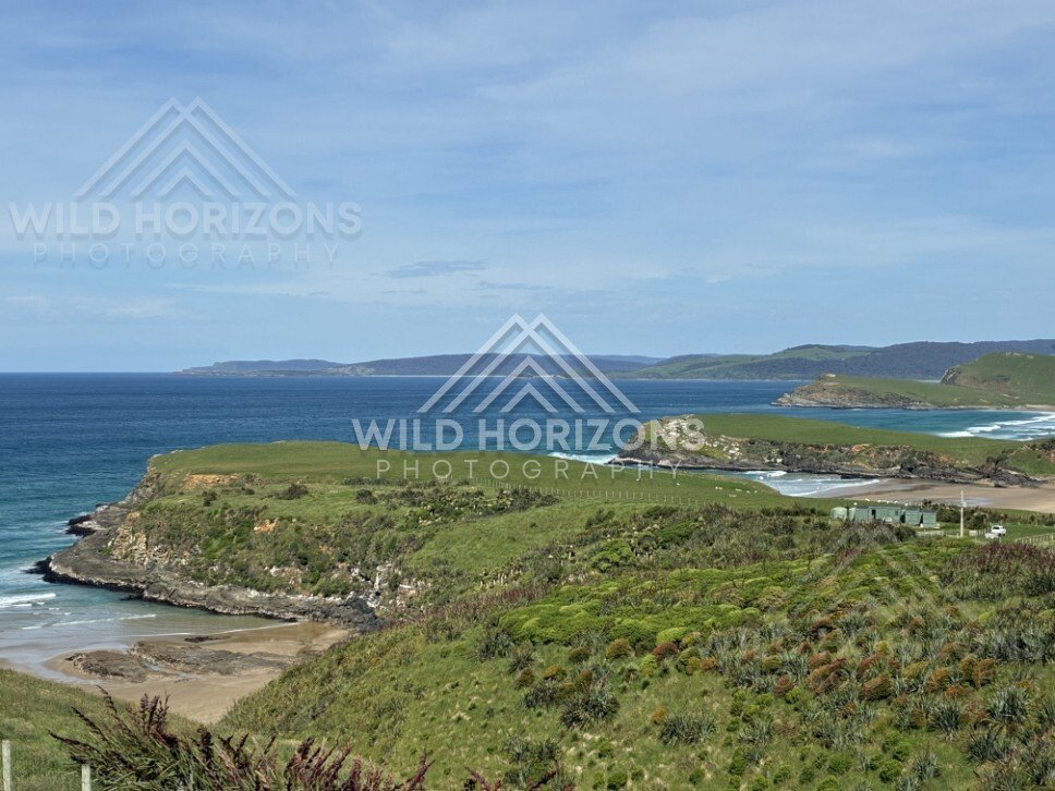 Coastal headland and farmland above sheltered bay. Helena Falls Beach, New Zealand.