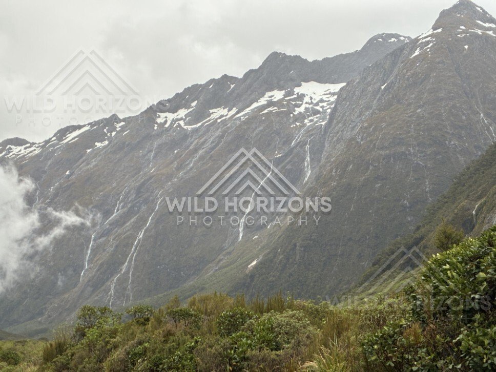 Jagged Fiordland Peaks with Thin Waterfalls After Rain. Milford Road, New Zealand.