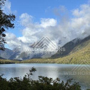 Mountain Lake with Cloud-Wrapped Peaks Beyond. Milford Road, New Zealand.