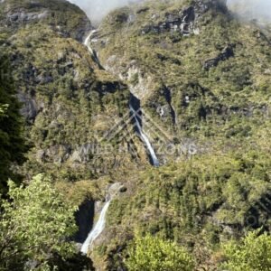 Multiple Waterfalls on a Cloud-Wrapped Mountainside. Milford Road, New Zealand.