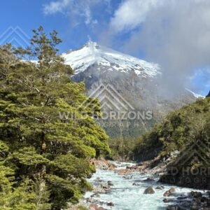 Turquoise River Rapids with Snow-Capped Peak Beyond. Milford Road, New Zealand.