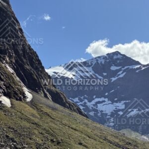 Snow-Streaked Mountain Face Rising Above an Alpine Valley. Milford Road, New Zealand.