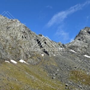Rocky Ridgeline and Scree Slope with Patches of Snow. Milford Road, New Zealand.