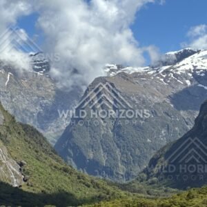 Wide Valley View with Snowy Peaks and Waterfall Threads. Milford Road, New Zealand.