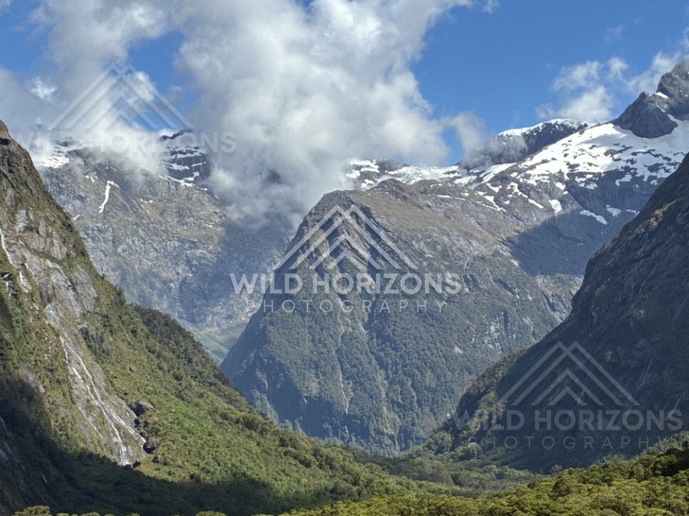 Wide Valley View with Snowy Peaks and Waterfall Threads. Milford Road, New Zealand.