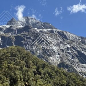 Massive Mountain Wall with Waterfalls and Forested Foothills. Milford Road, New Zealand.