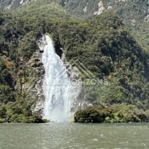 Waterfall Dropping Into Milford Sound from a Cliff Base. Milford Sound, New Zealand.