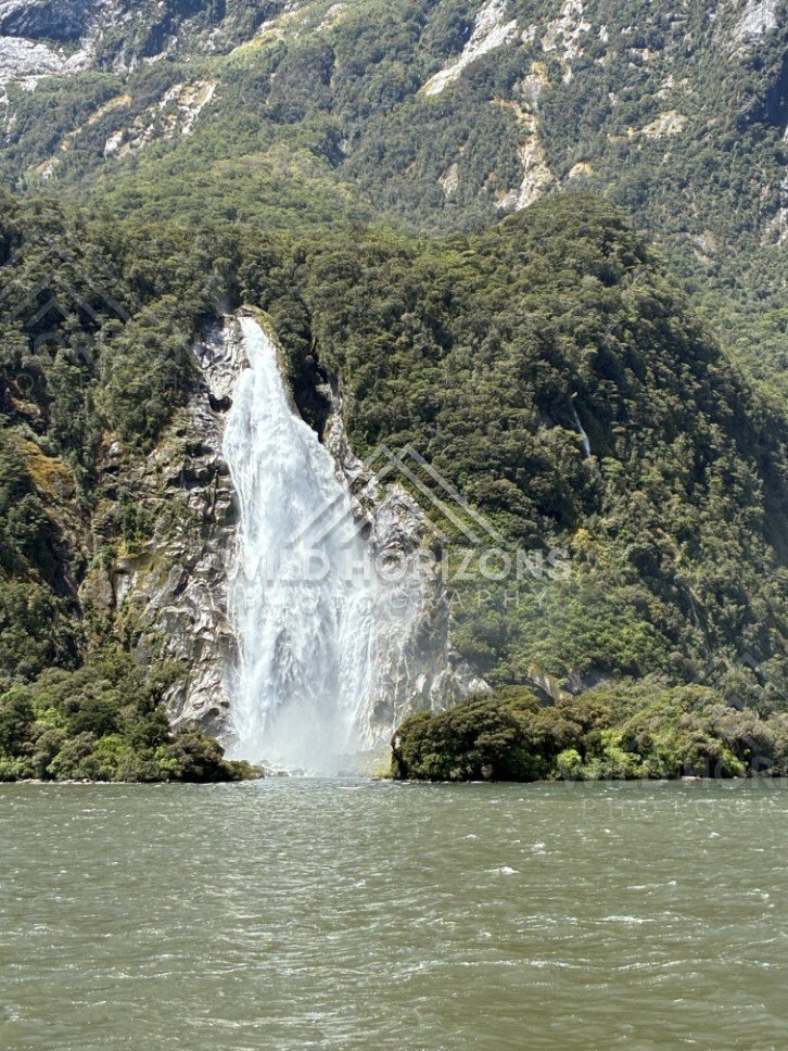 Waterfall Dropping Into Milford Sound from a Cliff Base. Milford Sound, New Zealand.