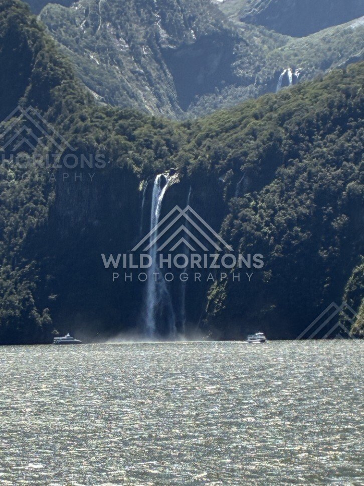 Twin Falls Plunging Into Milford Sound with Boats Below. Milford Sound, New Zealand.