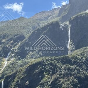 Multiple Waterfalls on a Steep Sunlit Mountainside. Milford Sound, New Zealand.