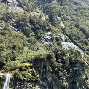 Forested Mountainside with Small Waterfalls Over Rock Slabs. Milford Sound, New Zealand.