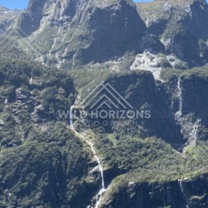 Tall Waterfall Dropping Over a Dark Fiord Cliff Face. Milford Sound, New Zealand.