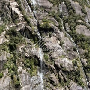 Waterfall Rushing Down a Granite Rock Face Above the Fiord. Milford Sound, New Zealand.