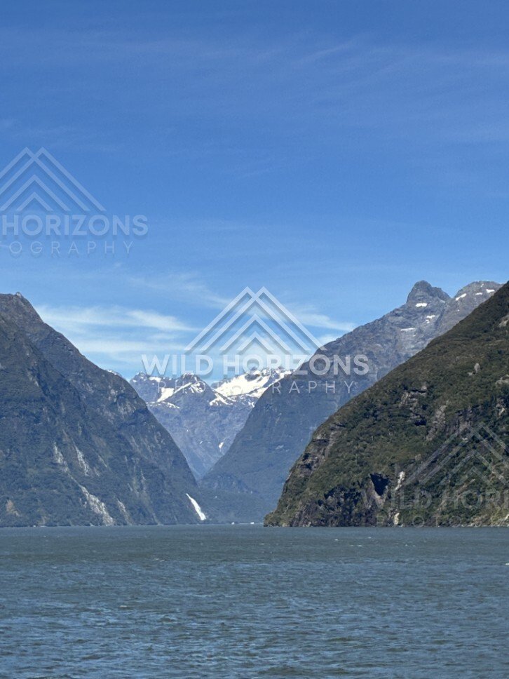 Distant Mountain Peaks and Calm Water in Milford Sound. Milford Sound, New Zealand.