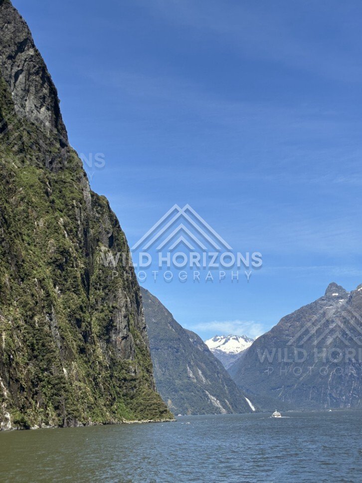 Milford Sound View with Sheer Cliff and Distant Peaks. Milford Sound, New Zealand.