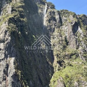 Steep Rock Wall with Waterfall Stream and Lush Vegetation. Milford Sound, New Zealand.
