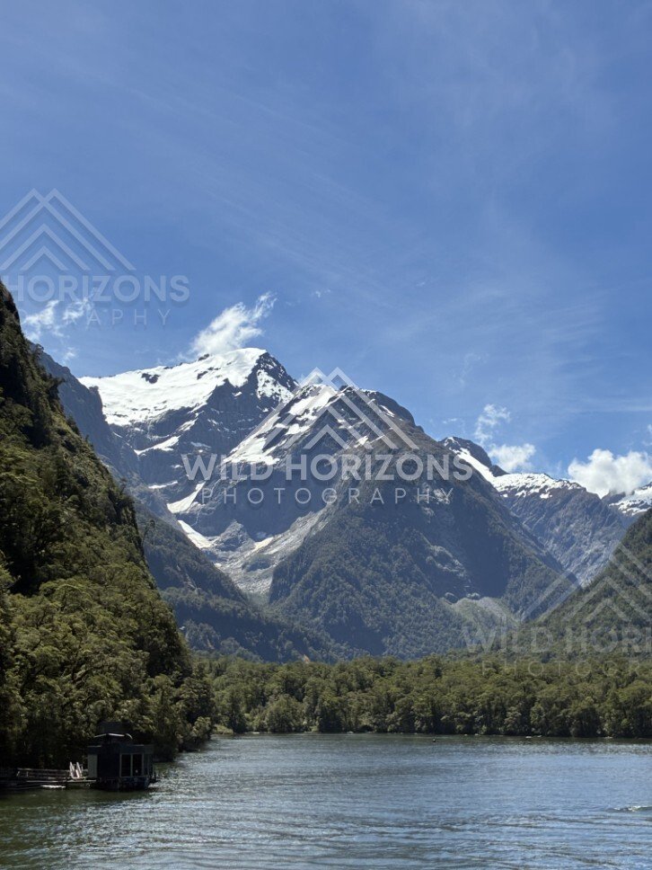 Alpine Valley and Snow-Dusted Peaks Under Clear Blue Sky. Milford Sound, New Zealand.