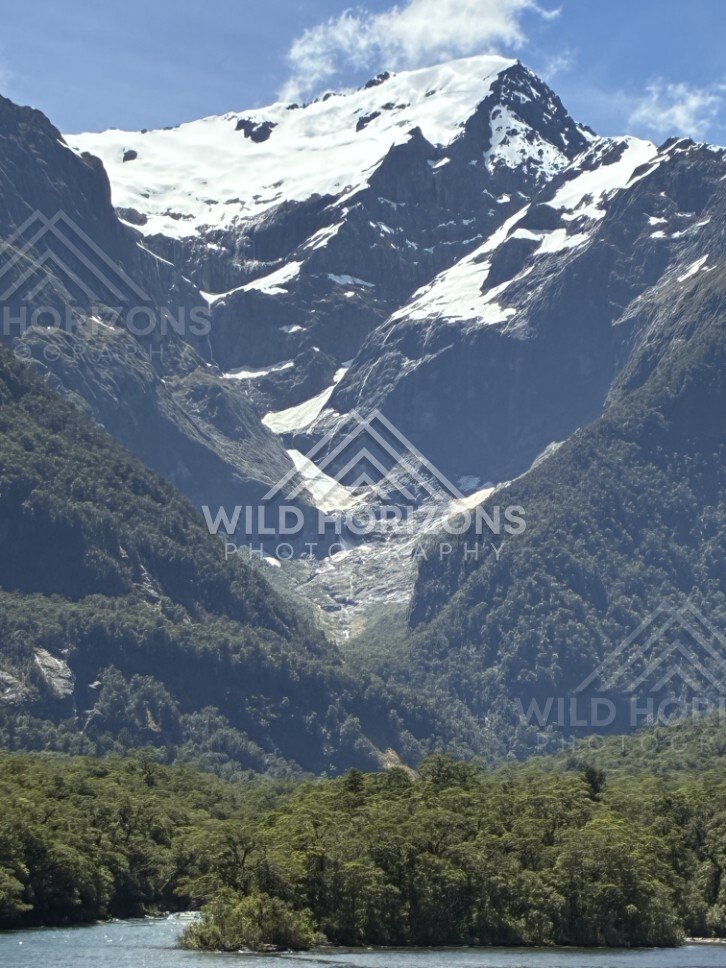Mountain Slopes and Snow-Capped Peaks Above Forested Valley. Milford Sound, New Zealand.