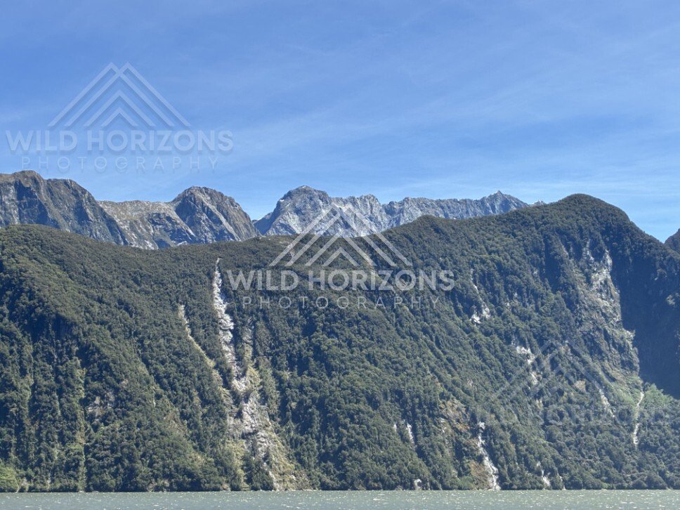 Layered Mountain Ridges and Forested Slopes in Clear Conditions. Milford Sound, New Zealand.