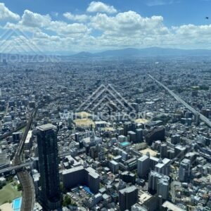 Osaka Skyline Stretching Toward Distant Mountains Under a Clear Blue Sky. Umeda Sky Building, Osaka, Japan.