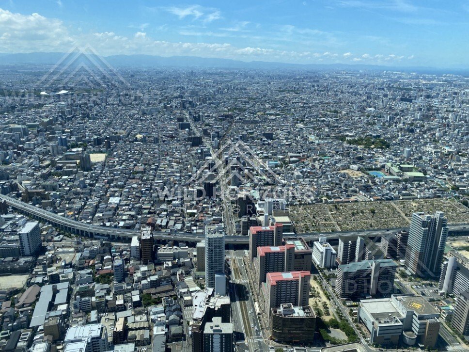 Wide Aerial Cityscape of Osaka with a Central Transit Corridor and Expressways. Umeda Sky Building, Osaka, Japan.