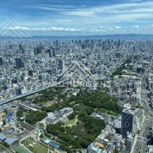 Osaka Skyline Above a Green Urban Park Under Layered Summer Clouds. Umeda Sky Building, Osaka, Japan.