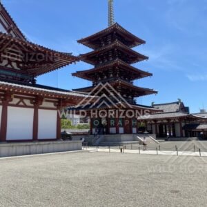 Temple Courtyard Leading to a Multi-Tier Pagoda Under Clear Blue Sky. Shitennoji Temple, Osaka, Japan.
