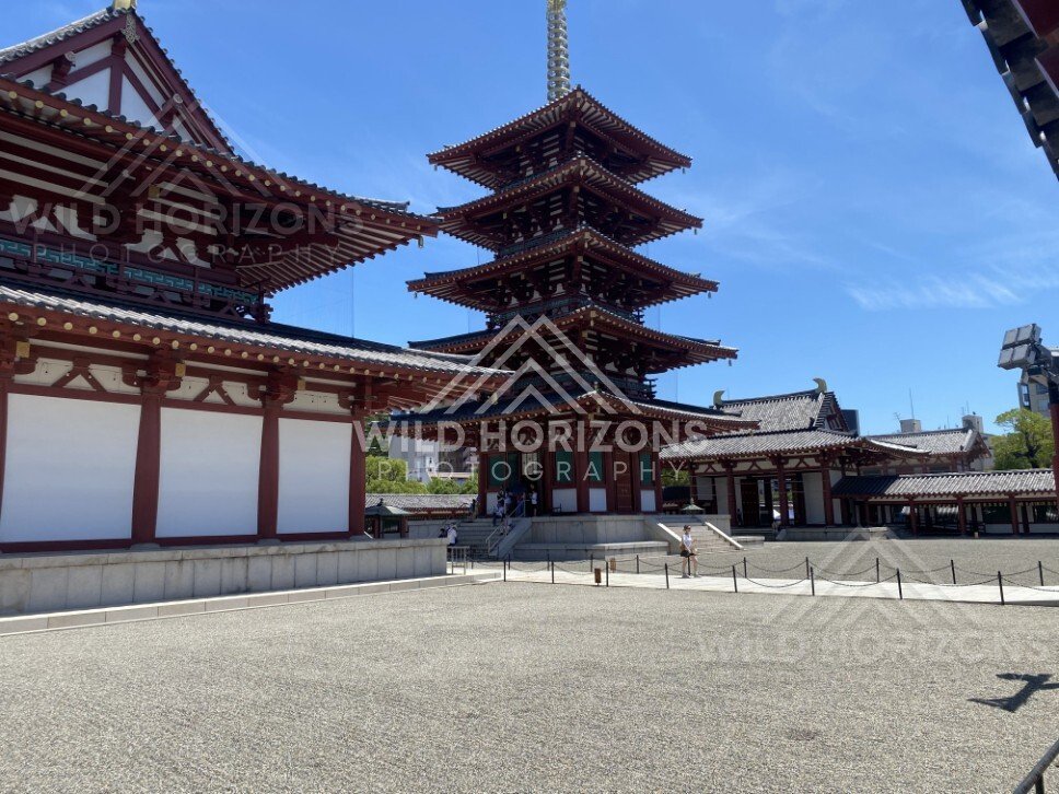 Temple Courtyard Leading to a Multi-Tier Pagoda Under Clear Blue Sky. Shitennoji Temple, Osaka, Japan.