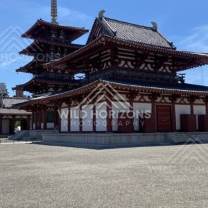 Close View of Temple Hall with Pagoda Tiers Rising Behind the Roofline. Shitennoji Temple, Osaka, Japan.