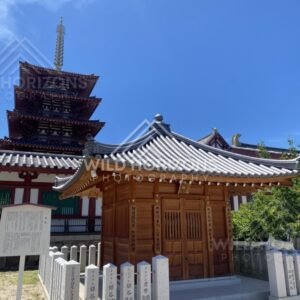 Small Shrine Pavilion with Tiled Roof and Pagoda Rising Behind the Walls. Shitennoji Temple, Osaka, Japan.