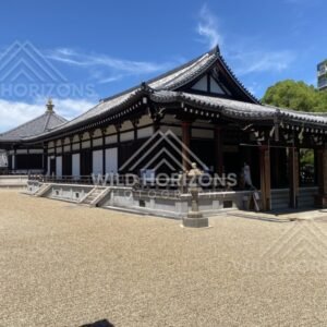 Traditional Temple Hall with Veranda and Stone Lantern Beside a Gravel Courtyard. Shitennoji Temple, Osaka, Japan.