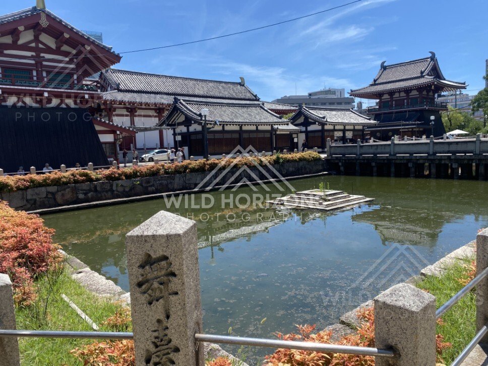 Temple Pond with Reflections of Traditional Rooflines and Bridge Over Green Water. Shitennoji Temple, Osaka, Japan.