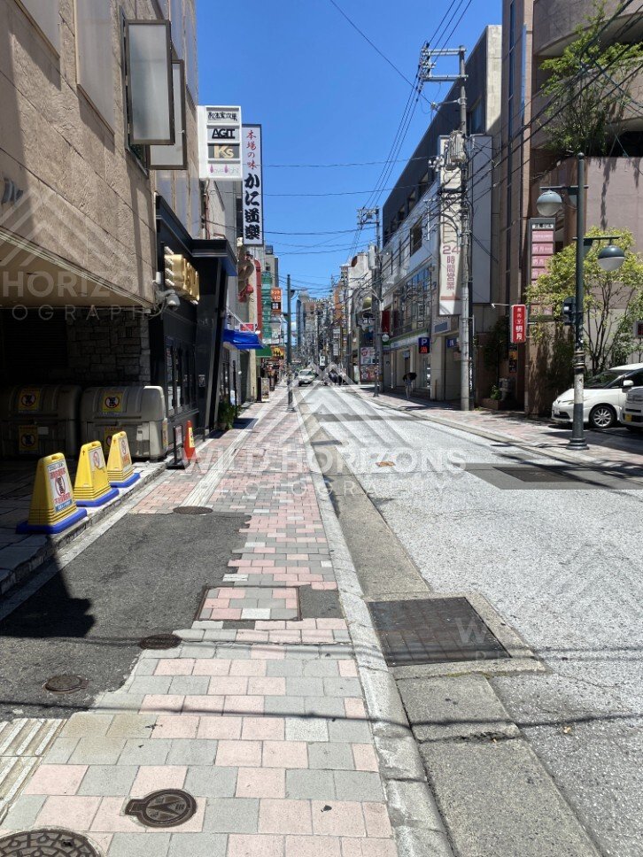 Quiet side street lined with shops and signage in central Hiroshima. Hiroshima, Japan.