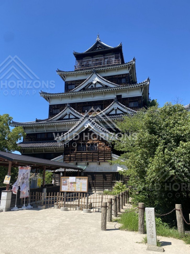 Front view of Hiroshima Castle with layered rooflines and dark timber. Hiroshima Castle, Hiroshima, Japan.