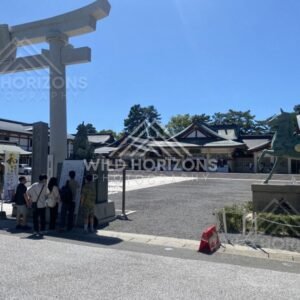 Stone torii gate and shrine courtyard in bright sunlight. Hiroshima, Japan.